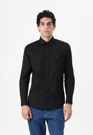 Zwarte langemouwen shirt met een button-down kraag, slim fit, met voortoeven en een klein rood en wit logo op de borst.
