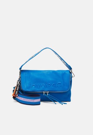 Sac à bandoulière en cuir bleu vif avec logo embossé, fermeture éclair argentée, sangle amovible avec texte « LIFE IS AWESOME » et étiquettes colorées attachées.