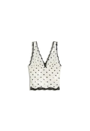 Bela brezrokavnik z izrezom z čipko, črnimi pikicami in valovitim robom, z globokim V-izrezom.
