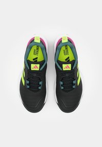 Black athletic shoes with textured material, featuring neon green accents and pink highlights. Rubber sole with laces and branded details.