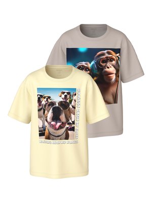 Δύο κοντομάνικα t-shirts με σχέδια ζώων: το ένα μπεζ με ένα χιμπατζή που φορά γυαλιά και ακουστικά, το άλλο εκρού με σκύλους που φοράνε γυαλιά ηλίου.