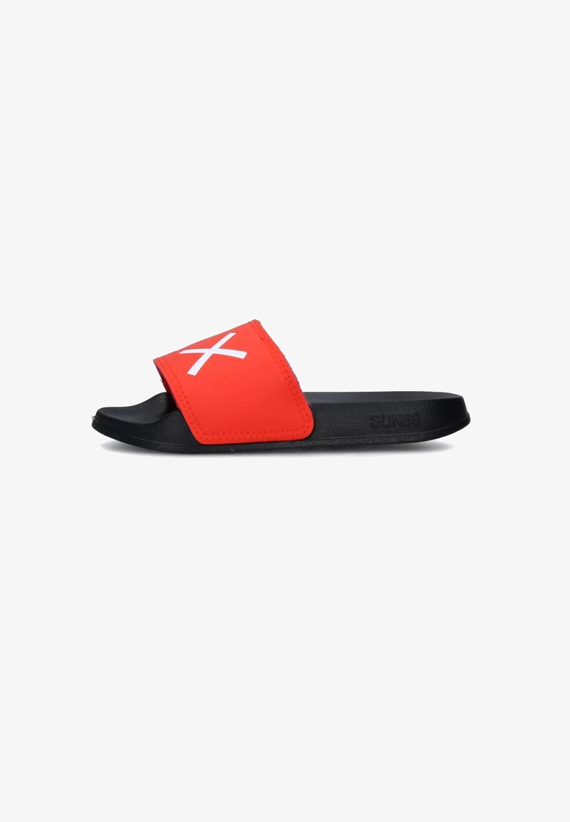 Sandale noire à enfiler avec une lanière rouge ornée d'un symbole blanc en forme de "X" sur le dessus, conçue pour un usage décontracté.