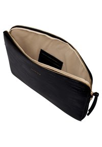 Zwarte leren clutch met krokodillenstructuur, gouden ritssluiting, beige voering en een binnensleuf voor kaarten. Gladde afwerking en gestructureerde vorm.