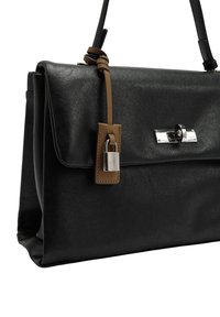 Czarna skórzana torebka o zorganizowanej konstrukcji, z metalowym zapięciem, brązowym skórzanym paskiem z akcentem w postaci zamka oraz fakturowaną powierzchnią.