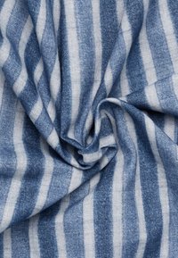 Tessuto a righe blu e bianche, caratterizzato da una texture morbida e un design pieghettato. Le righe variano in larghezza, creando un aspetto stratificato.