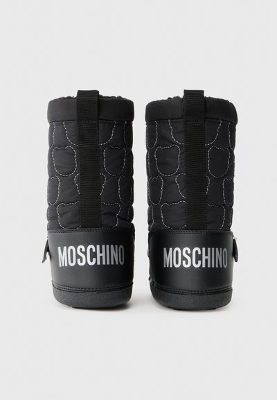 Svarte quiltede støvler med teksturert overdel, svarte gummisåler og hvit Moschino-logo på hælen. Har svarte trekkremmer for enkel påkledning.