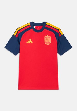 Tricou sportiv roșu și bleumarin cu mâneci scurte, având logo-ul Adidas și emblema echipei naționale a Spaniei, cu accente galbene dungi pe umeri.