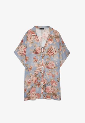 Kortærmet skjorte med knapper i lyseblå med pink og beige blomstermønster og bindedetalje ved halsudskæringen.
