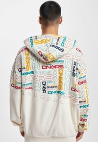 Hooded sweatshirt featuring a multicolor logo pattern on the upper portion, solid cream lower half, and textured lettering "DANGEROUS" on the back.