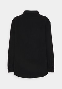 Camicia nera con colletto, maniche lunghe e vestibilità rilassata. Tessuto liscio con una trama semplice, senza motivi o accenti visibili.