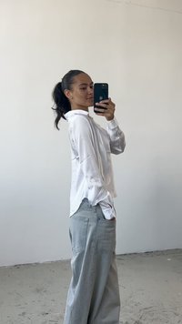 Hvid langærmet skjorte med krave, afslappet pasform; lysegrå brede jeans; glat stoftekstur; minimalistisk design.