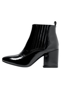 Botas negras hasta el tobillo con un acabado brillante de charol, tacón cuadrado, punta afilada y detalles de ribetes verticales en los laterales.