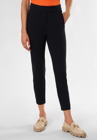 Marineblaue Tailored Trousers, schlanker Schnitt, mit glattem Material, seitlichen Taschen und zwei dekorativen Knöpfen am Bund.