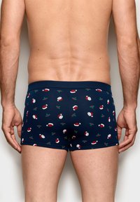 Dunkelblaue Boxer-Briefs aus weichem Stoff, mit einem Muster aus Weihnachtsmannmützen und Stechpalmenblättern, mit einem enganliegenden elastischen Bund.