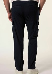 Námořnické cargo kalhoty s uvolněným střihem, které mají více bočních kapes a elastický pas. Tkanina vypadá lehce a odolně.