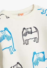 Sudadera blanca con estampados de perros de dibujos animados en negro y azul. Cuello redondo, tela suave, puños y dobladillo acanalados.