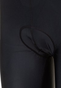 Leggings negros con una textura suave, que presentan un corte ovalado y detalles de costura en contraste a lo largo de las costuras.