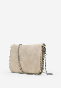 Bolso cruzado de imitación cuero beige con una correa de cadena, textura lisa y acentos de cuentas plateadas a lo largo de los bordes. Forma rectangular compacta.