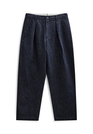 Pantalones plisados azul oscuro con bolsillos delanteros, cierre de botón y cremallera, y forro de cinturilla blanco visible.