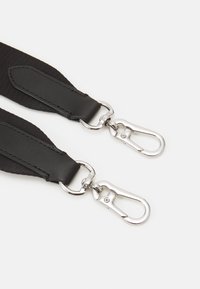 Nastro in tessuto nero e pelle con clip metalliche argentate su entrambe le estremità, caratterizzato da una texture liscia e un design piatto per un facile attacco.