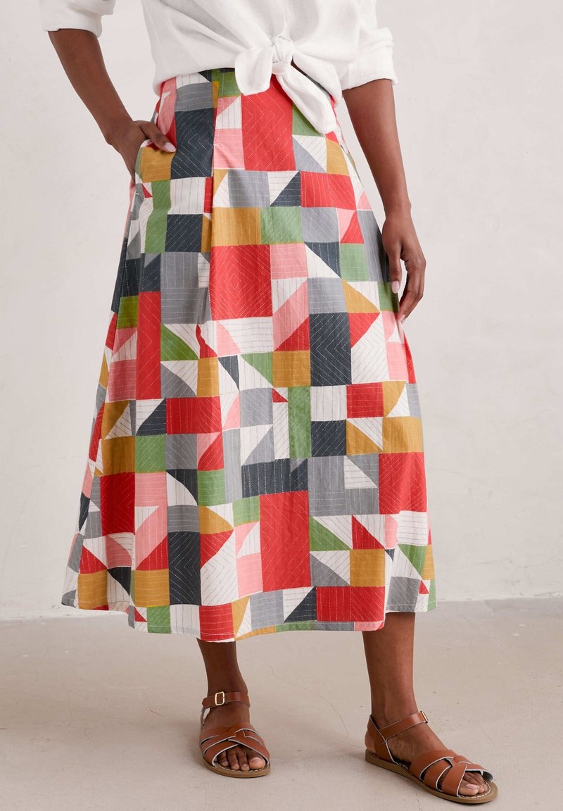 Jupe midi multicolore en coton avec motifs géométriques en rouge, vert, gris et blanc ; dotée d'une coupe évasée et de poches latérales.