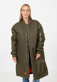 Olijfgroene lange bomberjack met een ritssluiting, ribgebreide manchetten en een oranjekleurige voering. Heeft een zijzak met rits en een merkembleem.