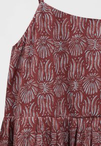 Robe sans manches avec fines bretelles, en tissu bordeaux texturé orné de formes florales abstraites bleu clair.