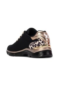 Zapatilla deportiva negra con parte superior de tejido texturizado, acentos dorados y una sección de estampado de leopardo en el talón. Suela de goma para agarre y soporte.
