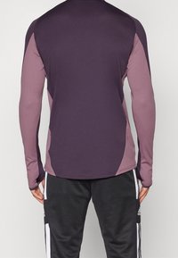 Langärmliges Sportshirt in dunkelpink und hellpink Paneelen, aus dehnbarem Material mit einer taillierten Passform und flachen Nähten.