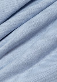 Tessuto di maglia blu chiaro con una trama liscia, caratterizzato da fibre distribuite uniformemente e una caduta morbida, che mette in risalto la sua qualità leggera e soffice.