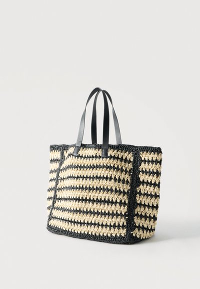 Ορθογώνια τσάντα ώμου πλεκτή με ρίγες σε μαύρο και μπεζ χρώμα και δύο μαύρα δερμάτινα λουριά στον ώμο σε λευκό φόντο.