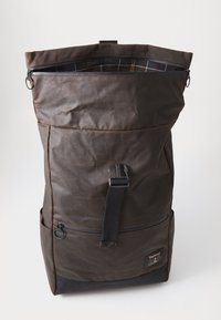 Dark brown roll-top backpack with black strap buckle, front zip pocket, side pockets, and plaid fabric lining inside the top opening.
