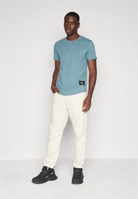 Calvin Klein Jeans BADGE TURN UP SLEEVE - T-shirts - goblin blue