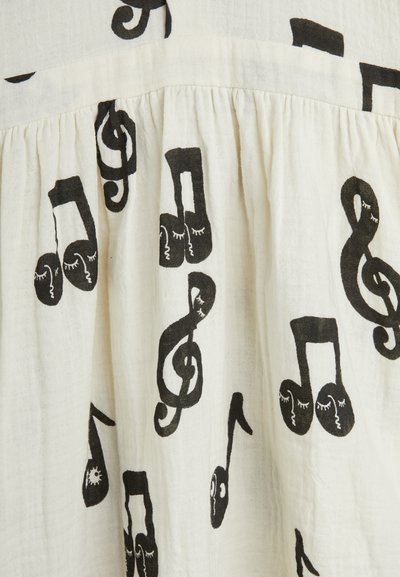White fabric with black music note patterns, featuring various note shapes with whimsical details, gathered texture along the top.