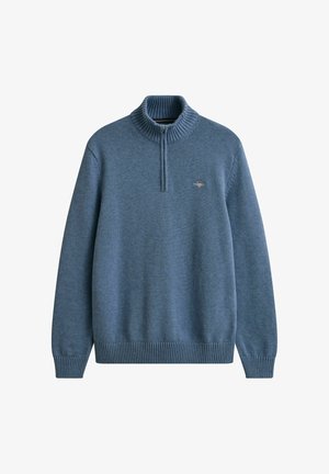 Blauwe gebreide pullover met lange mouwen, geribde kraag, boorden en zoom, en een kwart ritssluiting aan de voorkant met een klein geborduurd logo op de borst.