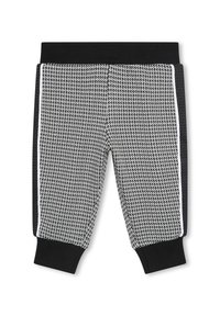 Jogging en noir et blanc avec un motif à chevrons texturé, doté d'une ceinture élastique noire et de bandes latérales en noir et blanc.