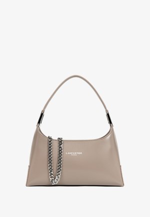 Sac à main en simili cuir beige avec une silhouette arrondie, accent en chaîne argentée et détails de logo sur le devant. Il dispose d'une seule bandoulière.