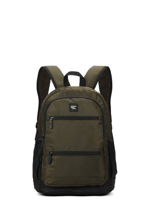 Sac à dos vert olive avec accents noirs, deux poches avant zippées, poches latérales en mesh, bretelles rembourrées et une poignée supérieure pour le transport.