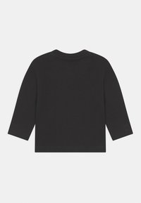 T-shirt noir à manches longues avec un col rond, fabriqué en coton. Présente des coutures simples sans motifs ni accents visibles.