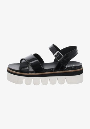 Sandal in pelle nera lucida con platform e suola bianca ondulata chunky, dotato di cinturino alla caviglia regolabile con fibbia in argento.