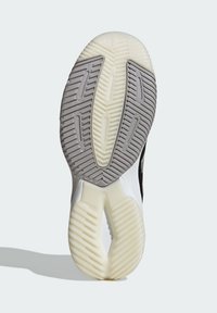 Zwart-witte zool van een sportschoen met gestructureerd grijs rubber en een witte tussenzool, voorzien van geprofileerde groeven voor grip.