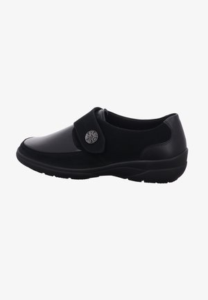 Black shoe with a smooth leather toe and soft suede body, featuring a round metal accent and a Velcro strap for easy fastening.