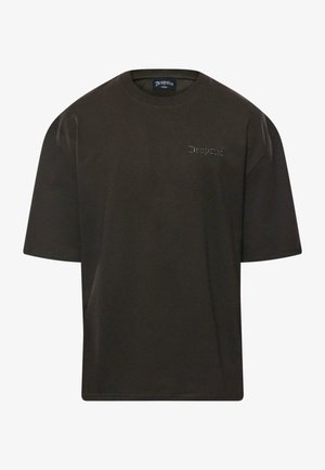 Sötétbarna, túlméretezett póló rövid ujjakkal, kerek nyakkivágással és diszkrét hímzett logóval a mellrészen, kontrasztos színben. Pamut anyag.