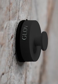 Apparecchio da parete circolare nero con superficie liscia, caratterizzato da una protuberanza centrale e un discreto marchio "GLOV".