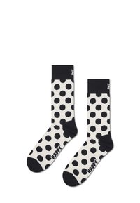 Chaussettes à pois noirs et blancs avec une bordure côtelée noire et un orteil noir. Logo "HAPPY" imprimé en noir sur le côté. Composition en mélange de coton.