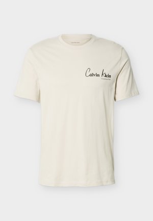 Εκρού κοντομάνικη μπλούζα με το λογότυπο Calvin Klein και το κείμενο «Established 1968» στο αριστερό στήθος, στρογγυλή λαιμόκοψη, απλό σχέδιο.