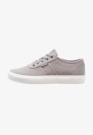 Zapatillas de lona grises con diseño de perfil bajo, puntera redonda, suela de goma blanca y rayas laterales tonales. Cierre con cordones y seis ojales.