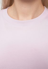 Ροζ βαμβακερό t-shirt με ριμπ λαιμόκοψη και ομαλή υφή, με ελάχιστες ραφές και καθαρό φινίρισμα.