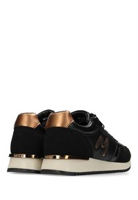 Černé tenisky z nubukové kůže a kůže, s bronzovými detaily na patě a texturovanou gumovou podrážkou. Mají výrazné logo na boku.