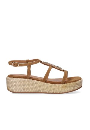 Sandalia de plataforma de ante marrón con suela gruesa tejida, correa al tobillo con hebilla y detalles decorativos de gemas en las correas superiores.